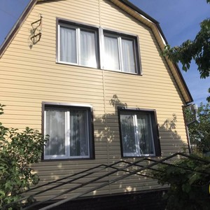 Монтаж цокольного сайдинга Ю-Пласт Stone House кирпич коричневый и отделка фасада сайдингом Альта-Профиль золотистый Корабельный брус