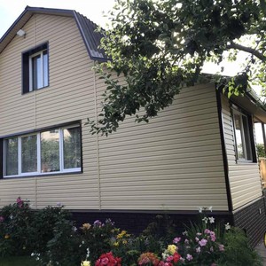 Монтаж цокольного сайдинга Ю-Пласт Stone House кирпич коричневый и отделка фасада сайдингом Альта-Профиль золотистый Корабельный брус