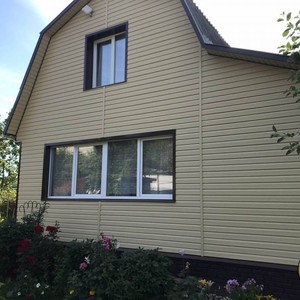 Монтаж цокольного сайдинга Ю-Пласт Stone House кирпич коричневый и отделка фасада сайдингом Альта-Профиль золотистый Корабельный брус