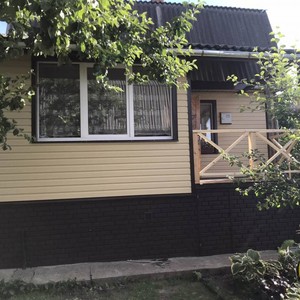 Монтаж цокольного сайдинга Ю-Пласт Stone House кирпич коричневый и отделка фасада сайдингом Альта-Профиль золотистый Корабельный брус