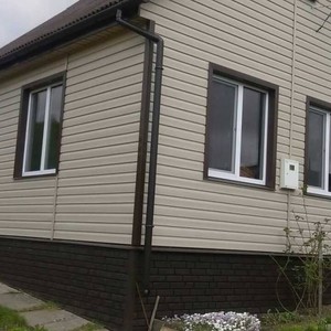 Монтаж цокольного сайдинга Ю-Пласт Stone House кирпич коричневый и отделка фасада панелями Ю-пласт Корабельный брус Бежевый