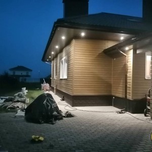 Отделка фасада сайдингом Hokla лиственница медовая и монтаж цоколя сайдингом Ю-пласт Stone House Кирпич коричневый