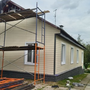 Монтаж фасада сайдингом Ю-пласт Корабельный брус Ванильный и монтаж цоколя сайдингом Стоун-хаус камень изумрудный